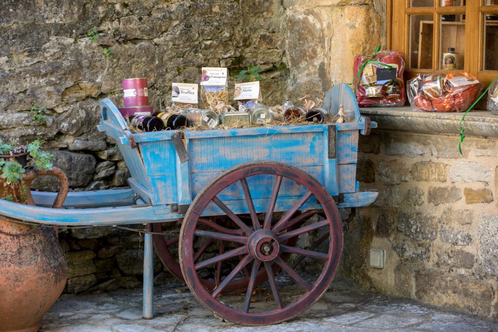 Old wooden blue cart full of local product for sale in Benyac. France